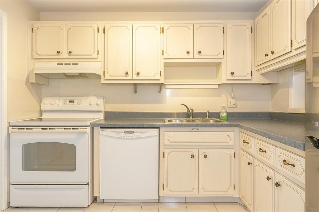 950 Hillcrest Drive, Unit 202 Hollywood, FL 33021 - Photo 3 of 19 a kitchen with granite countertop white cabinets and white appliances