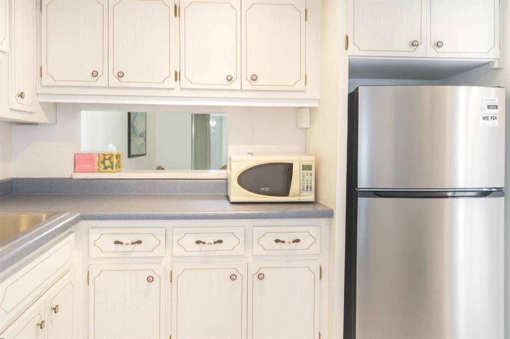 950 Hillcrest Drive, Unit 202 Hollywood, FL 33021 - Photo 4 of 19 a kitchen with granite countertop a refrigerator and a cabinets
