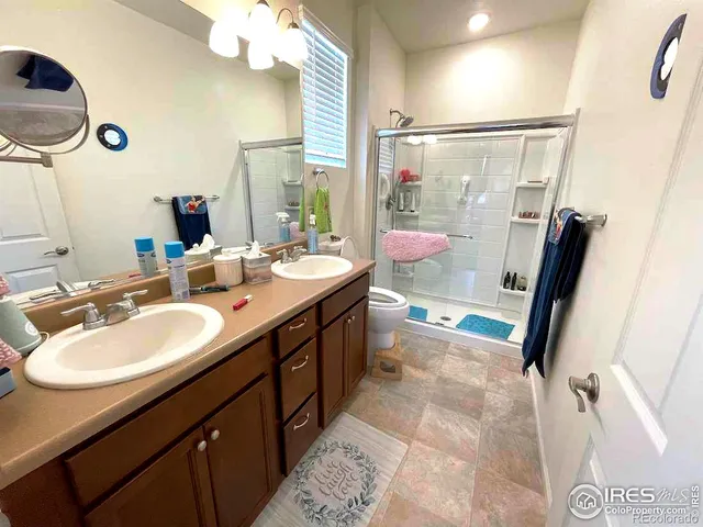 a bathroom with a double vanity sink a mirror and a shower