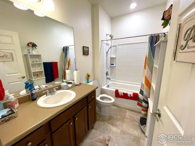 a bathroom with a granite countertop sink mirror vanity and toilet