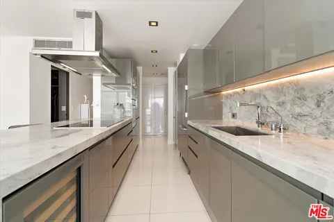 a large kitchen with a large counter top a sink a stove and a wooden floors