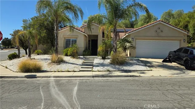 a view of a house with a yard and palm trees