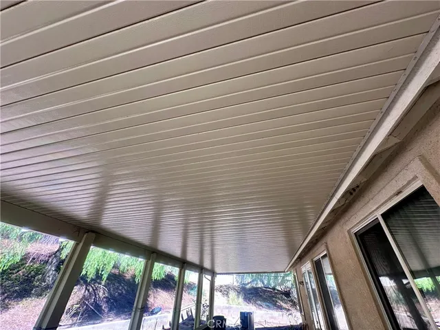 a view of a patio with table and chairs under an umbrella with wooden floor
