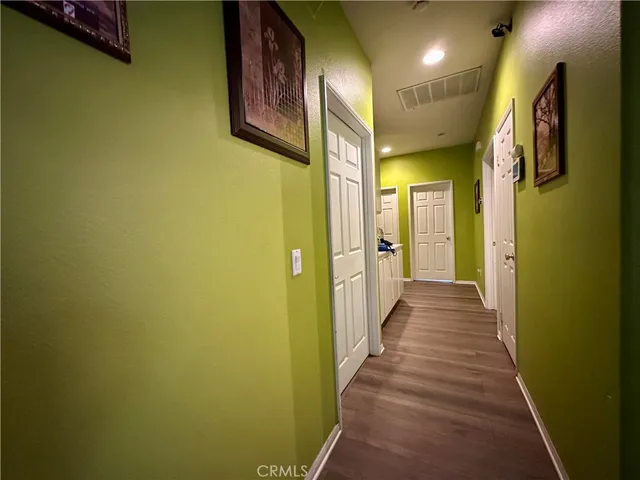 a view of a hallway with wooden shelves