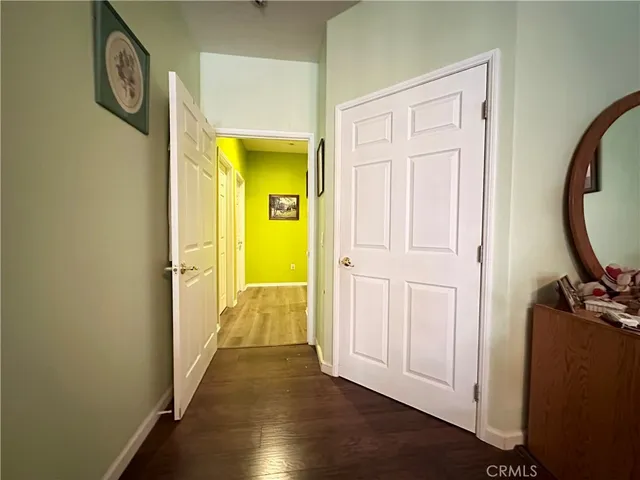 a view of a hallway with wooden floor and a livingroom
