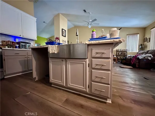 a kitchen that has a lot of cabinets in it and wooden floor