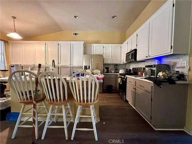 a kitchen with a table chairs sink and cabinets