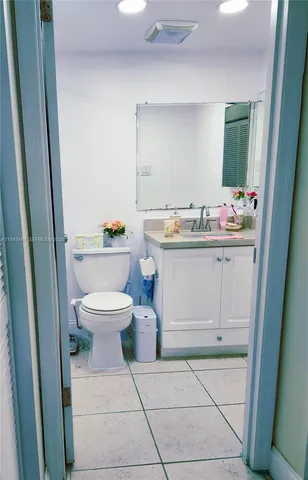 a bathroom with a toilet sink vanity and mirror