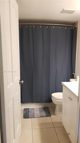 a bathroom with a toilet and a shower curtain