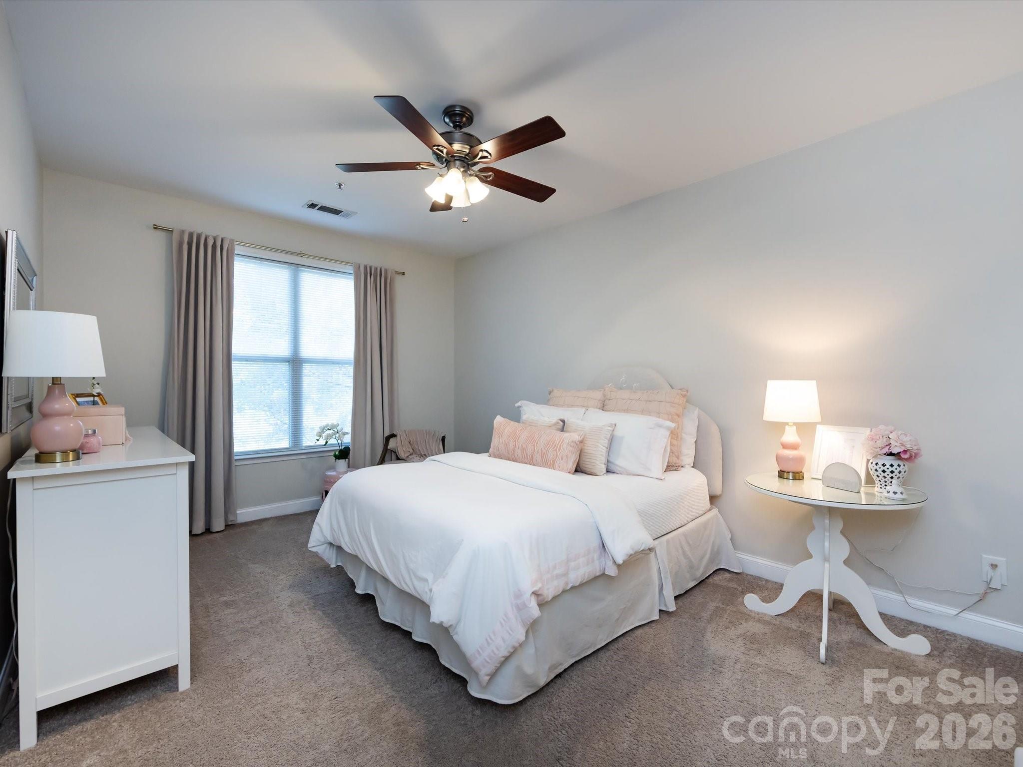 1000 East Woodlawn Road, Unit 113 Charlotte, NC 28209 - Photo 16 of 32 a bedroom with a bed and a chandelier