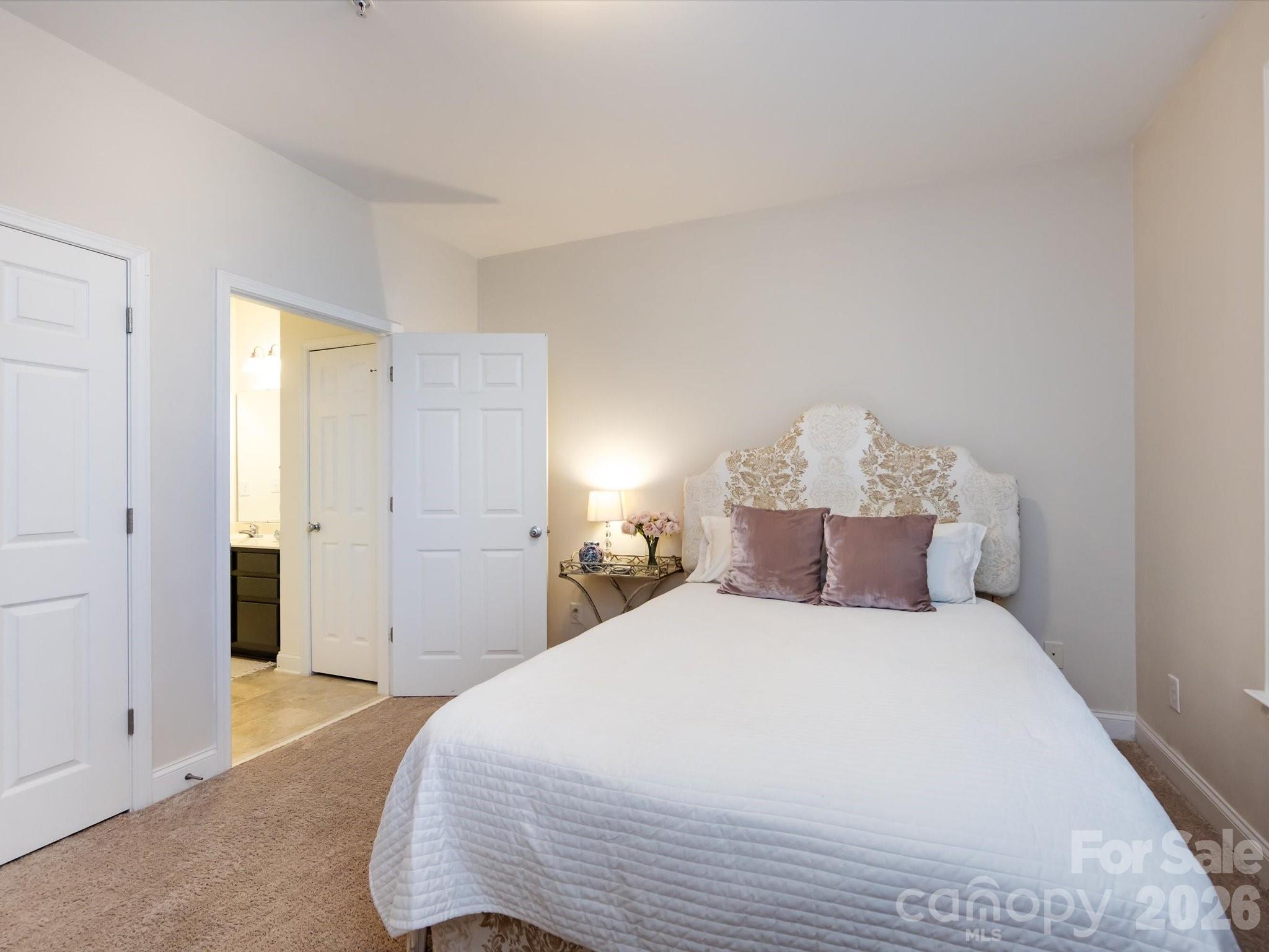 1000 East Woodlawn Road, Unit 113 Charlotte, NC 28209 - Photo 22 of 32 a bedroom with a large bed and a chandelier