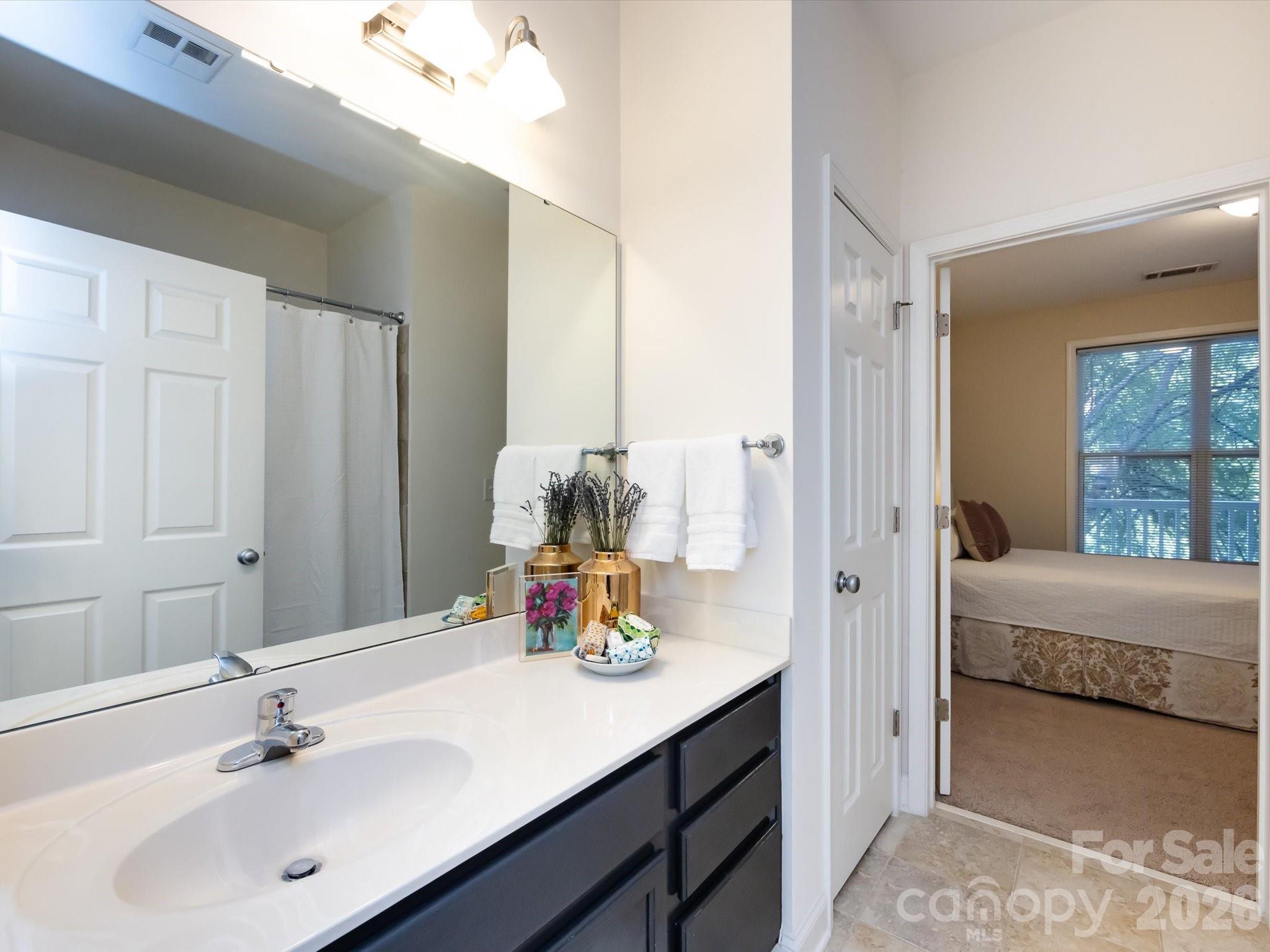 1000 East Woodlawn Road, Unit 113 Charlotte, NC 28209 - Photo 26 of 32 a en suite bathroom with a double vanity sink and a mirror