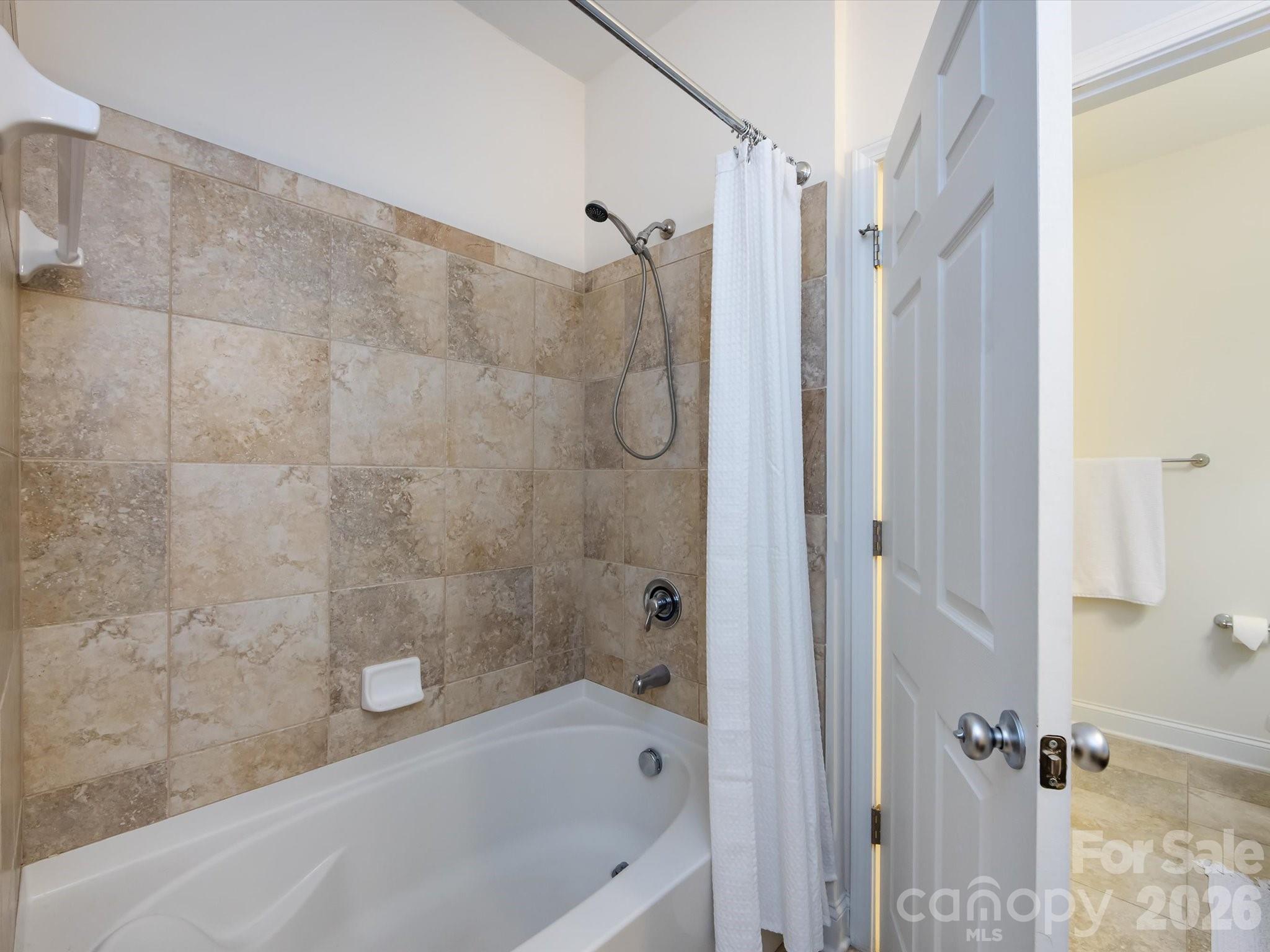 1000 East Woodlawn Road, Unit 113 Charlotte, NC 28209 - Photo 27 of 32 a bathroom with a bathtub and a shower