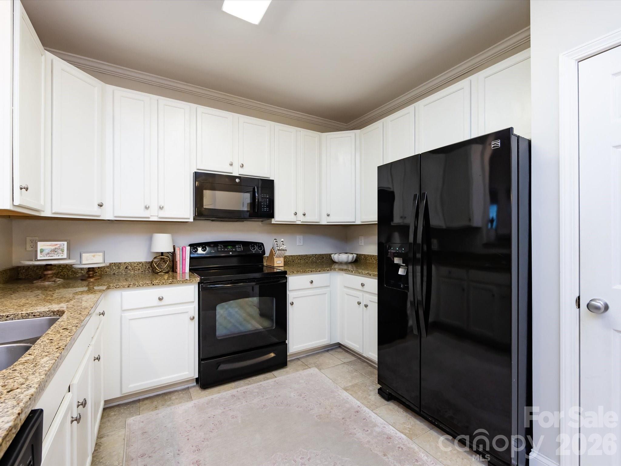 1000 East Woodlawn Road, Unit 113 Charlotte, NC 28209 - Photo 8 of 32 a kitchen with a refrigerator stove and a sink