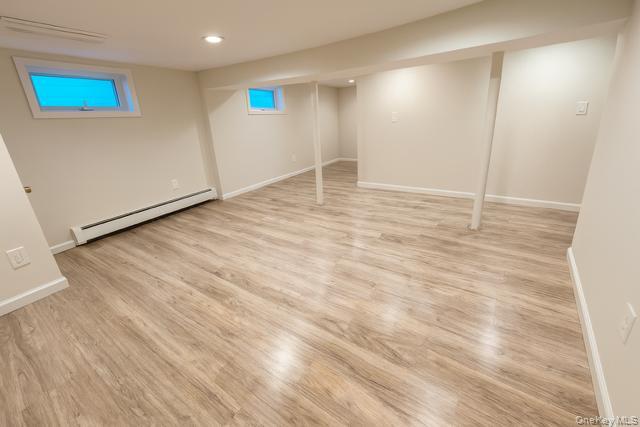 29 Avon Road Hewlett, NY 11557 - Photo 17 of 17 Basement with a baseboard heating unit, light wood-style floors, a wall unit AC, and recessed lighting