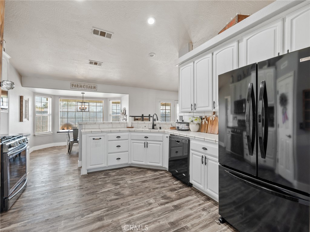 6370 Fremontia Road Hesperia, CA 92344 - Photo 26 of 62 a kitchen with white cabinets and stainless steel appliances