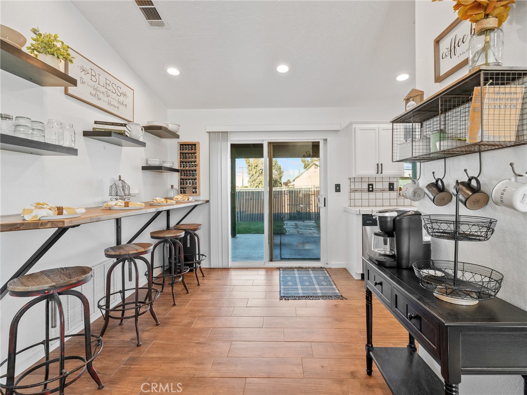 6370 Fremontia Road Hesperia, CA 92344 - Photo 53 of 62 a kitchen with stainless steel appliances granite countertop a stove top oven a sink a dining table and chairs with wooden floor