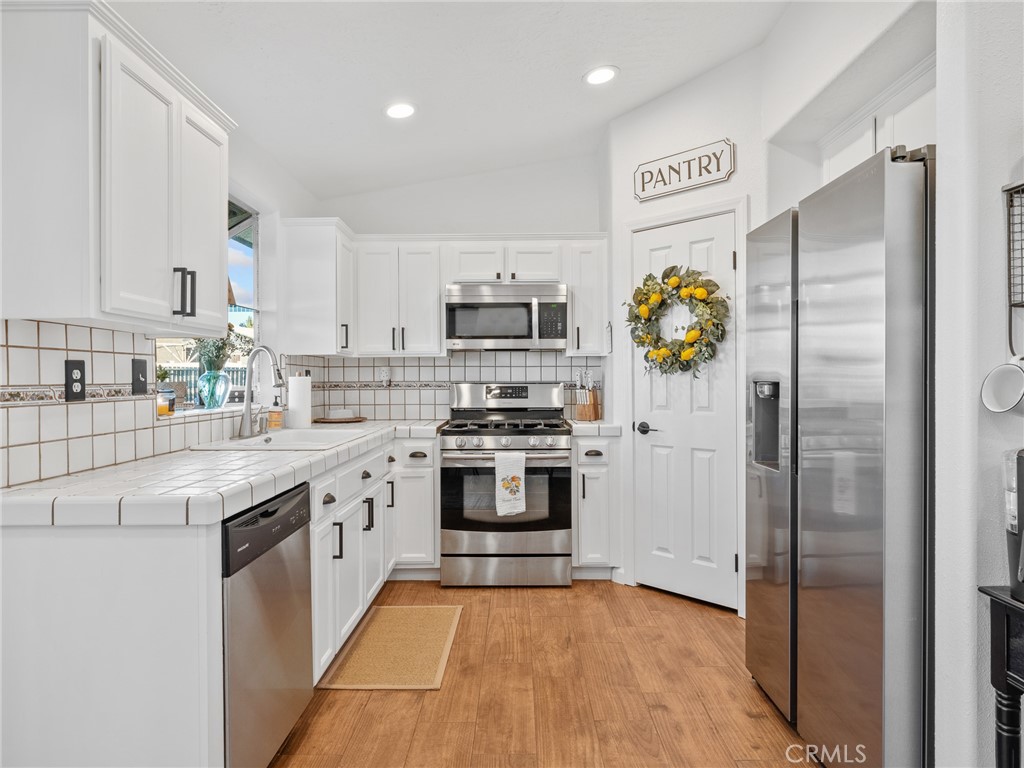 6370 Fremontia Road Hesperia, CA 92344 - Photo 55 of 62 a kitchen with stainless steel appliances granite countertop a refrigerator and a stove top oven