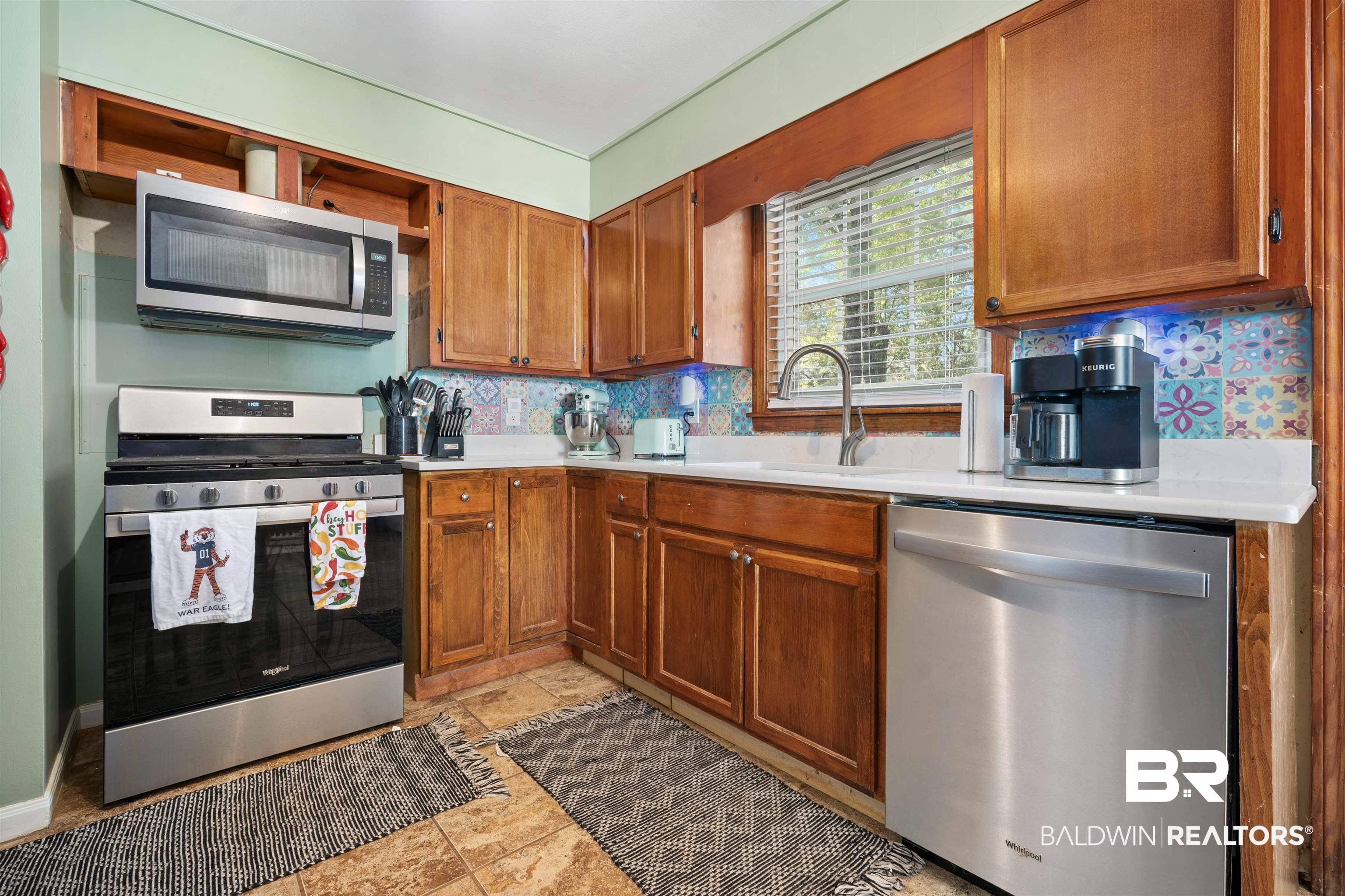 672 Tarawa Drive Mobile, AL 36609 - Photo 11 of 26 Kitchen with stainless steel appliances, light countertops, wood finish cabinetry, and backsplash