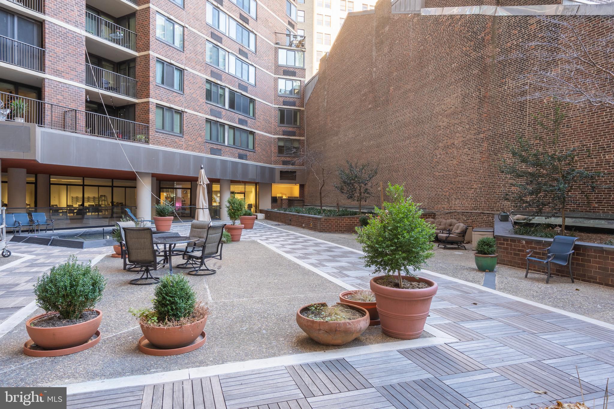 1420 Locust Street, Unit 7L Philadelphia, PA 19102 - Photo 23 of 25 a view of a patio with a dining table and chairs potted plants