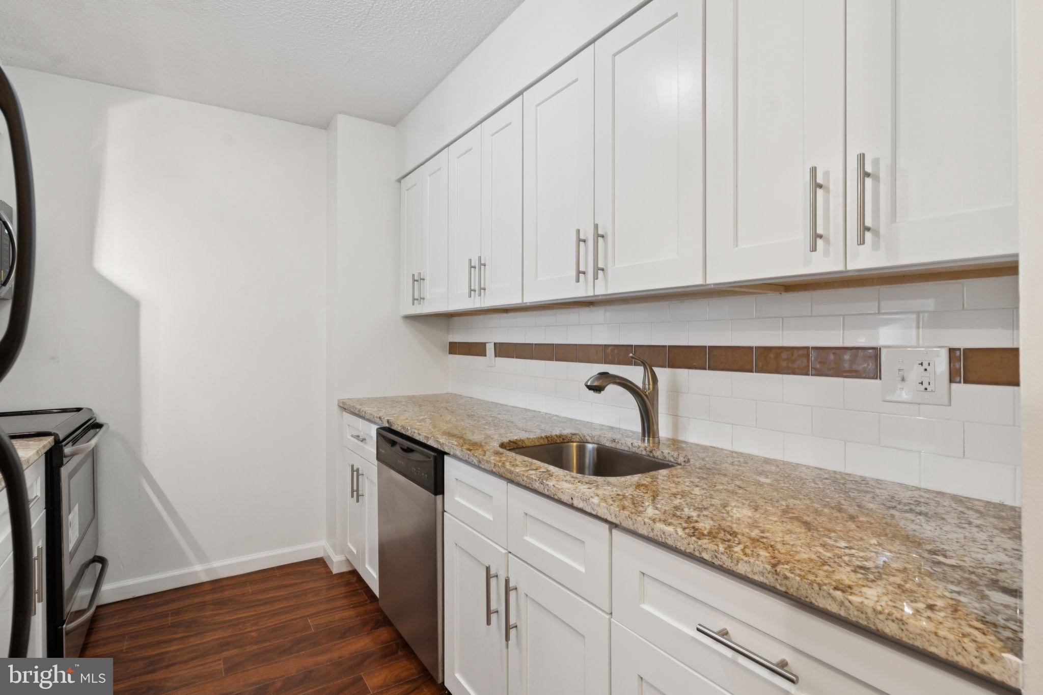 1420 Locust Street, Unit 7L Philadelphia, PA 19102 - Photo 5 of 25 a kitchen with granite countertop white cabinets and sink