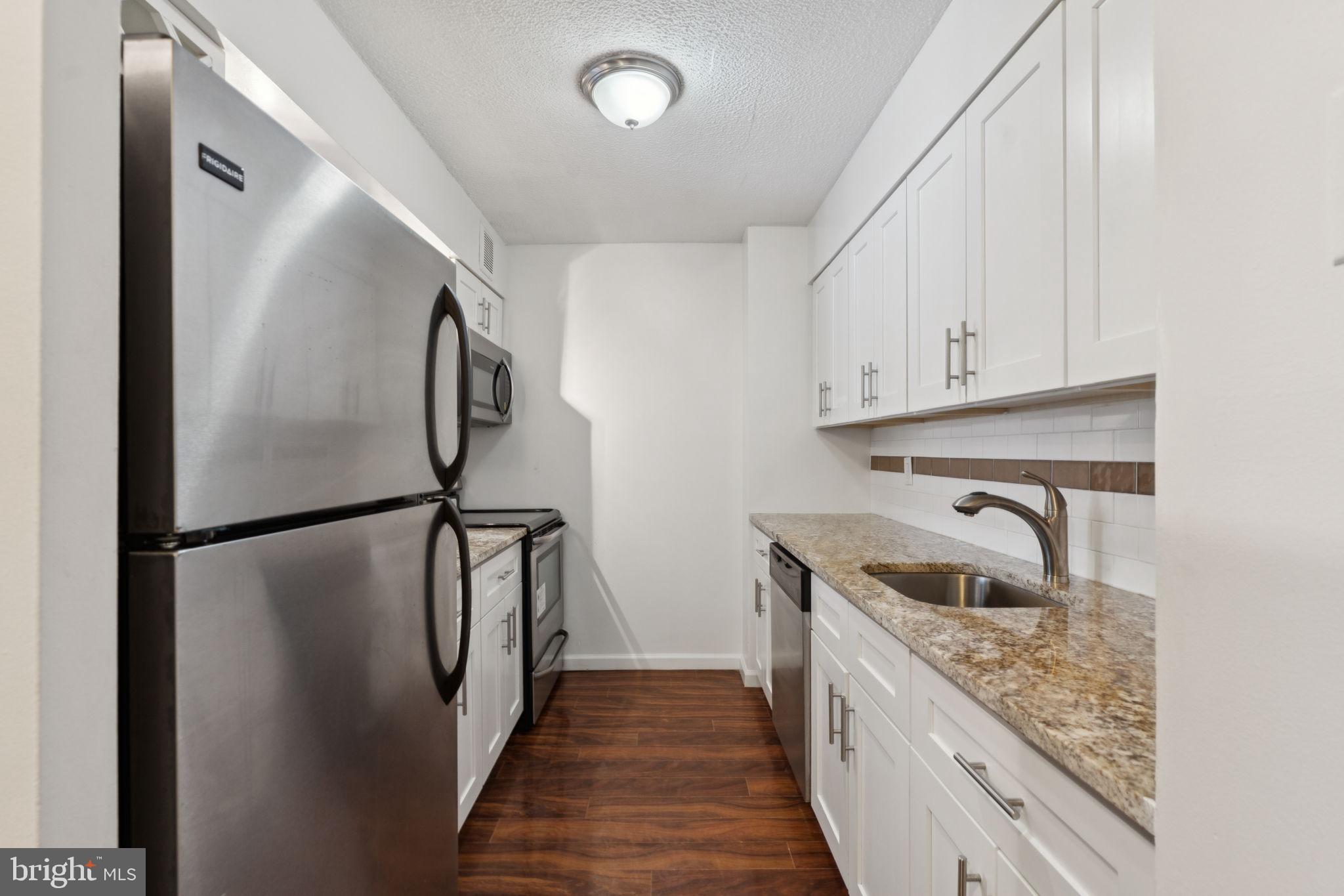 1420 Locust Street, Unit 7L Philadelphia, PA 19102 - Photo 7 of 25 a kitchen with a refrigerator sink and cabinets