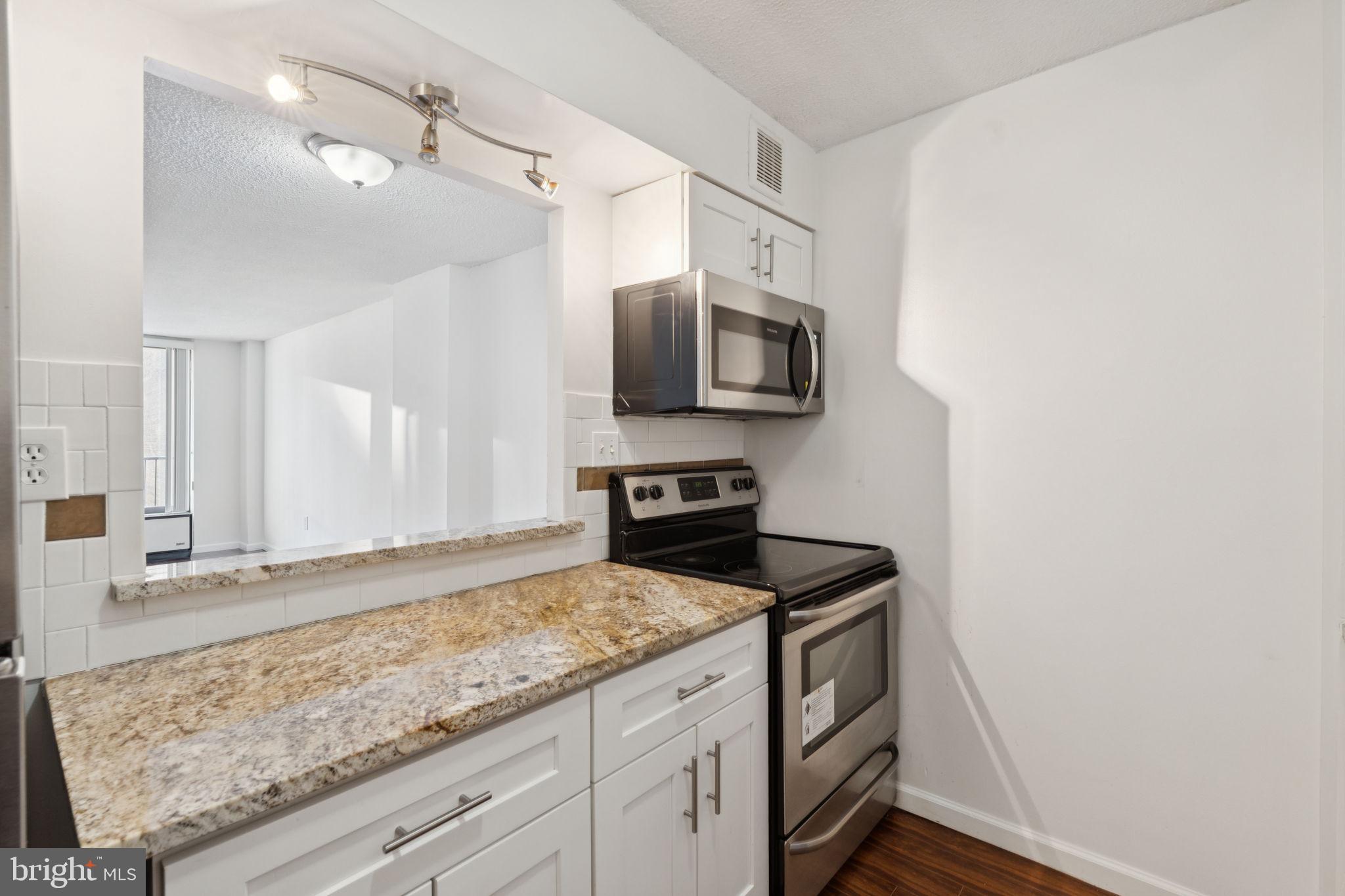 1420 Locust Street, Unit 7L Philadelphia, PA 19102 - Photo 8 of 25 a kitchen with granite countertop a sink and stainless steel appliances