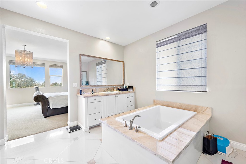 108 Fairgrove Irvine, CA 92618 - Photo 29 of 40 a bathroom with a tub a sink and a large mirror