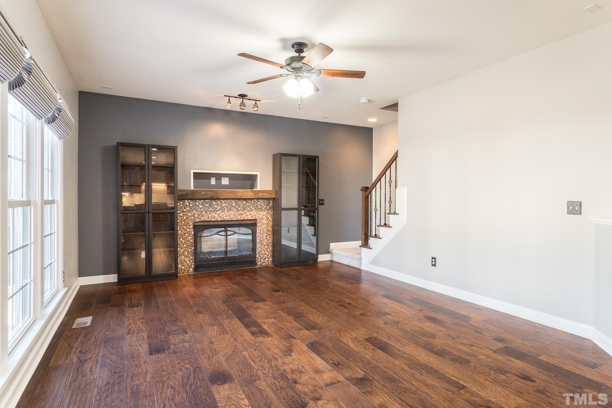 6023 Clapton Drive Wake Forest, NC 27587 - Photo 14 of 35 an empty room with windows fireplace and a kitchen view