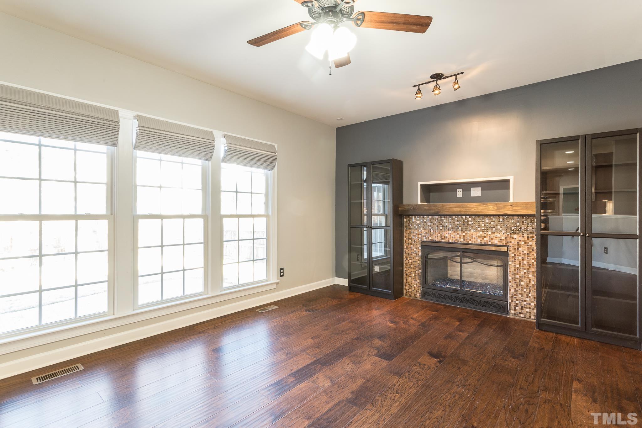 6023 Clapton Drive Wake Forest, NC 27587 - Photo 15 of 35 wooden floor fireplace and windows in an empty room