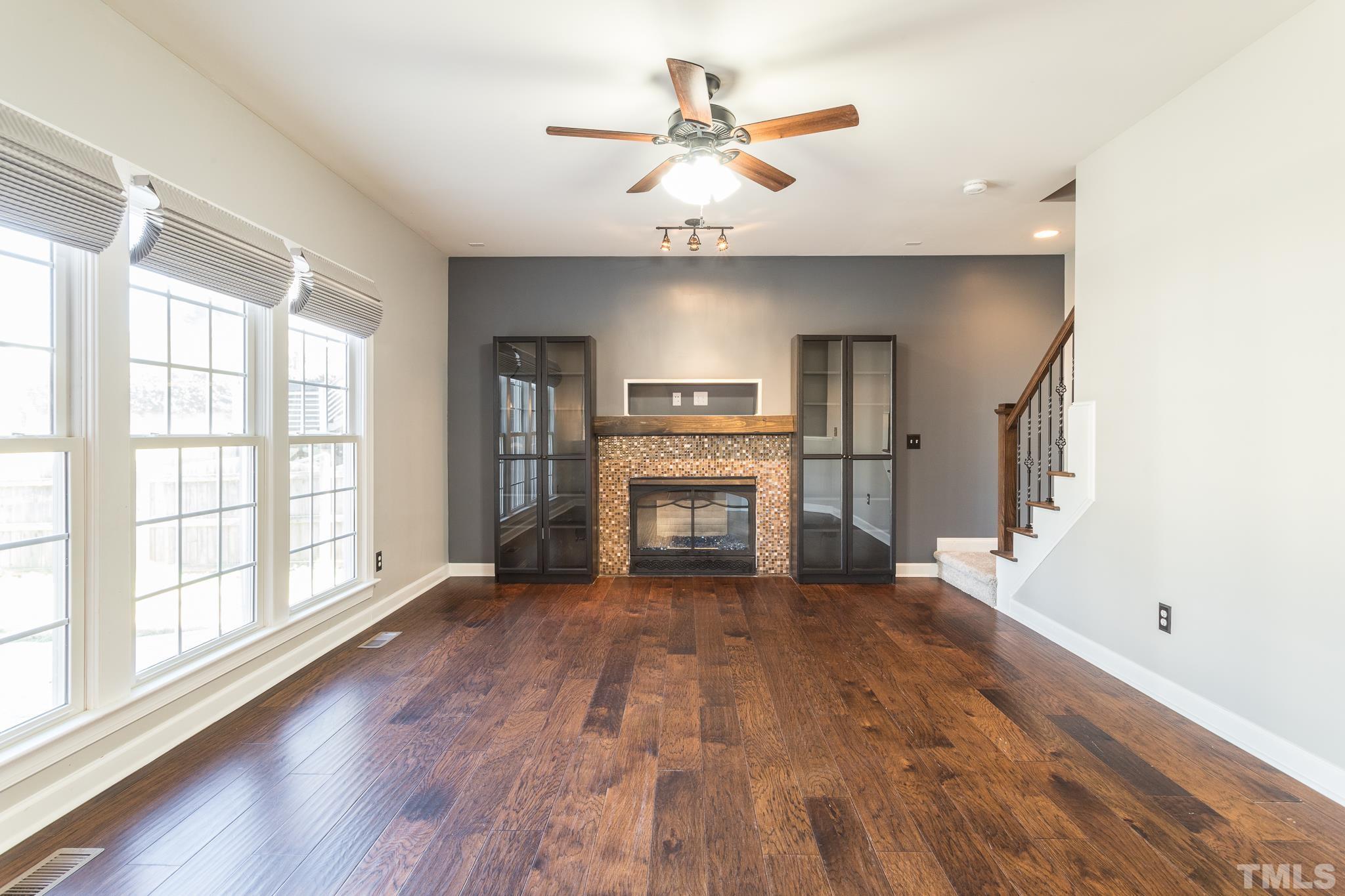 6023 Clapton Drive Wake Forest, NC 27587 - Photo 16 of 35 a view of a kitchen with a stove cabinets a ceiling fan and wooden floor