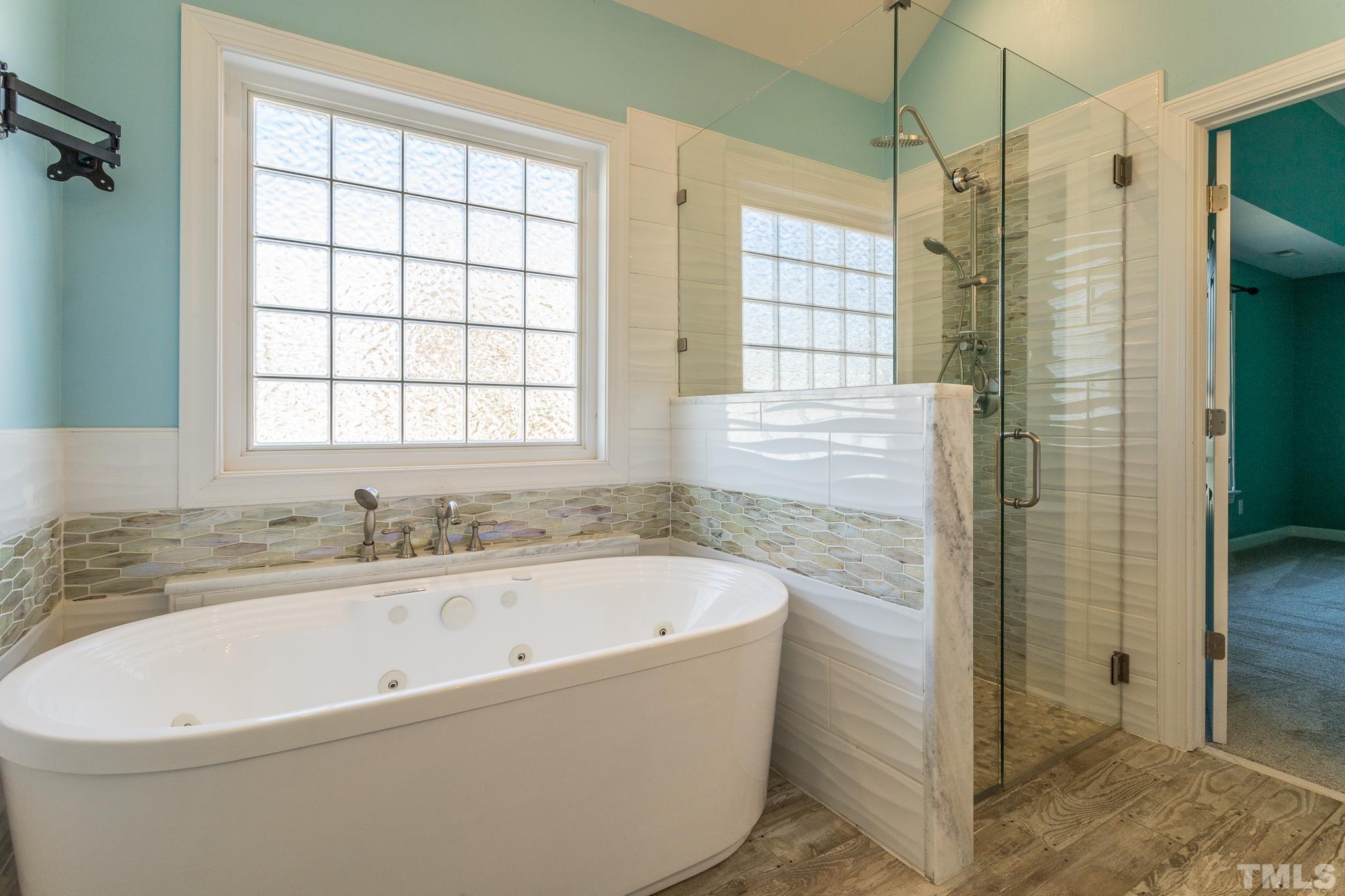 6023 Clapton Drive Wake Forest, NC 27587 - Photo 24 of 35 a white bath tub sitting next to a shower