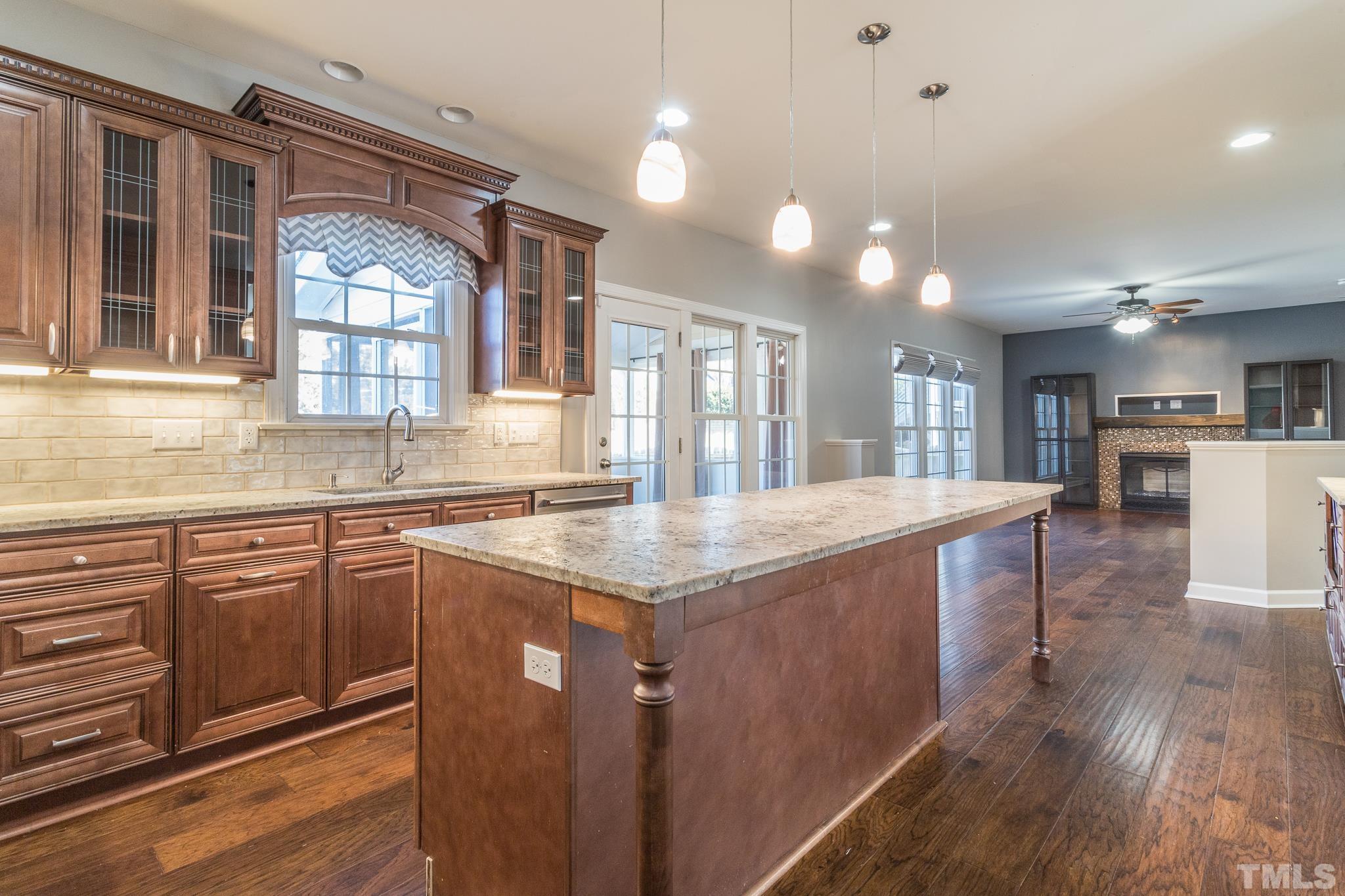6023 Clapton Drive Wake Forest, NC 27587 - Photo 7 of 35 a kitchen with stainless steel appliances granite countertop a sink a stove and a wooden floors