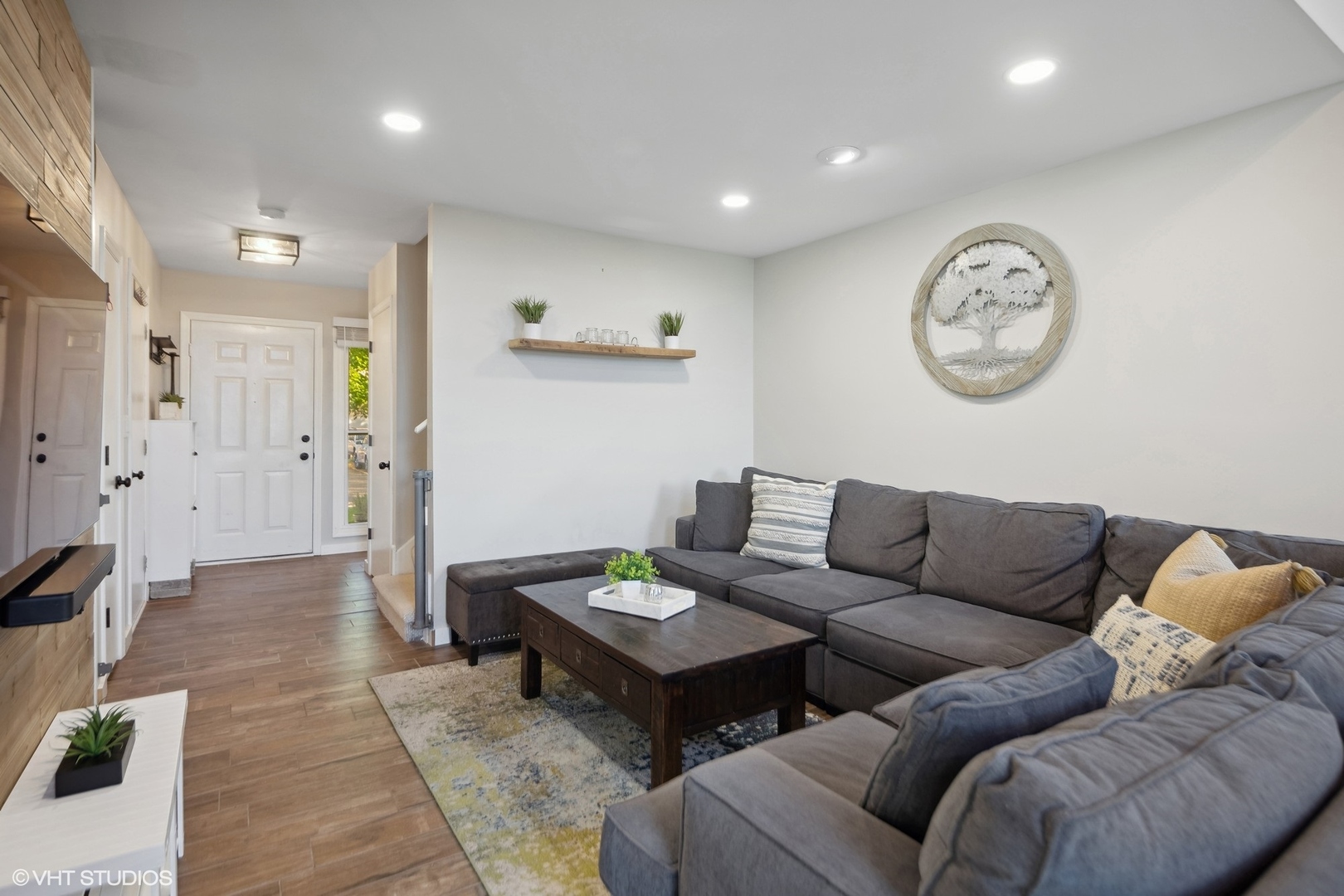 449 Wenbriar Square Addison, IL 60101 - Photo 4 of 35 a living room with furniture a clock on wall and a table