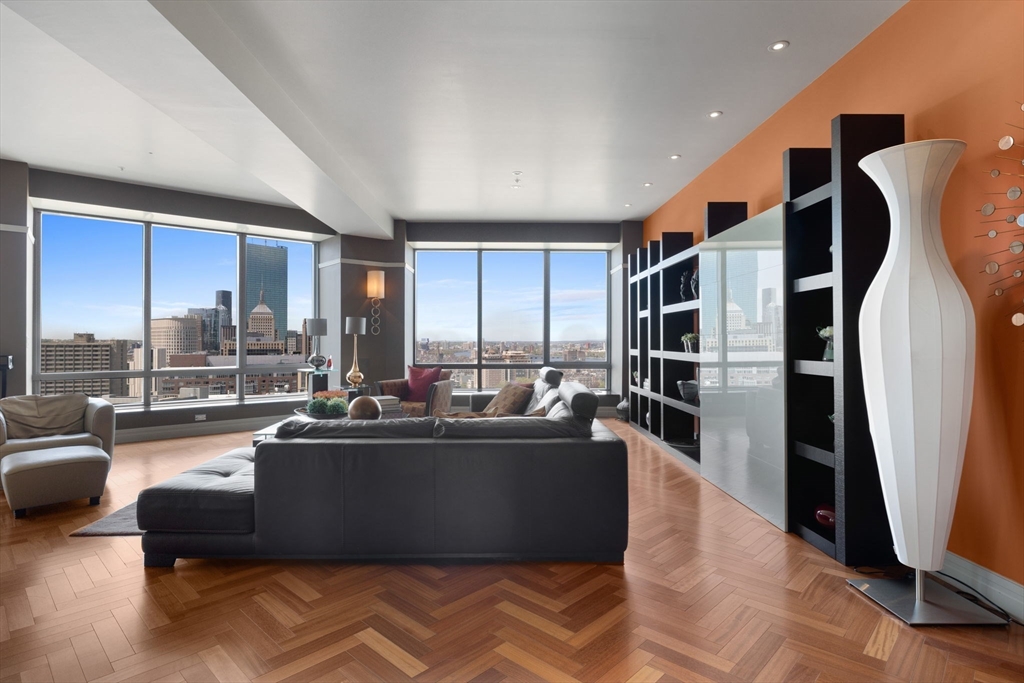 a living room with furniture floor to ceiling window and kitchen view