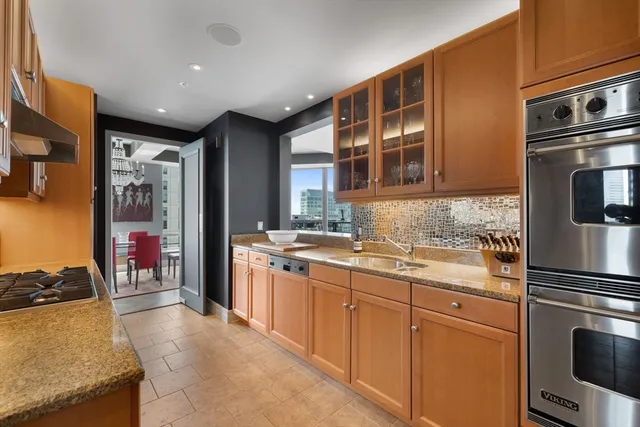 a kitchen with stainless steel appliances granite countertop a refrigerator and a stove top oven