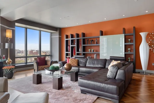 a living room with furniture and floor to ceiling windows