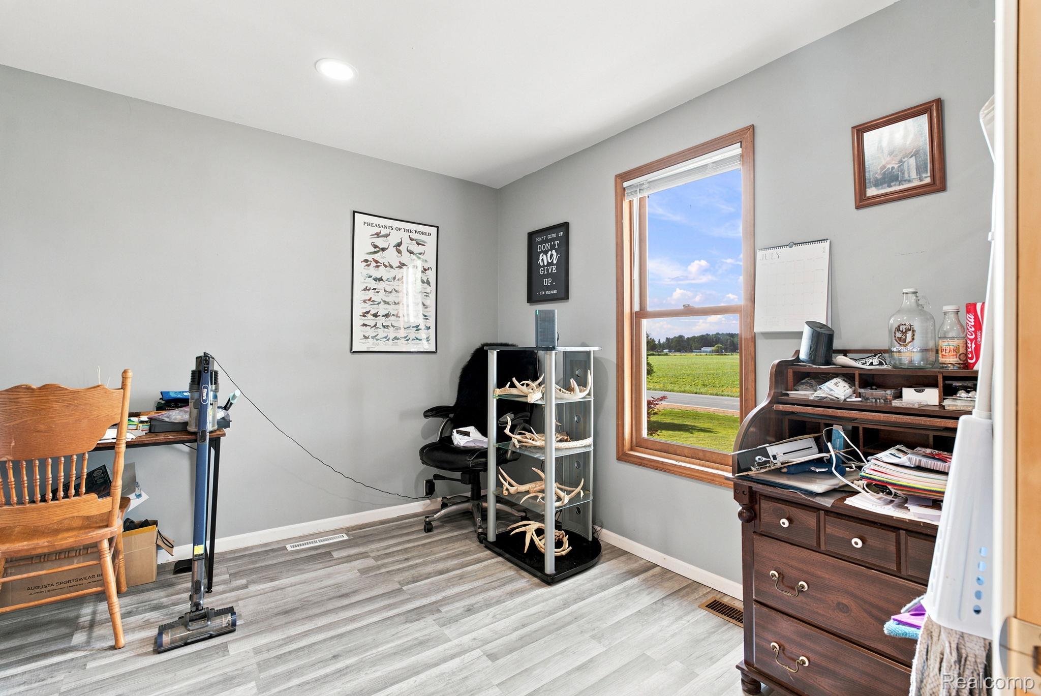 4201 Galbraith Line Road Croswell, MI 48422 - Photo 21 of 39 Bright room featuring wood-finish flooring, light gray walls, a recessed ceiling light, and a prominent wood-framed window