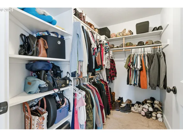 a view of walk in closet with clothes and shoes