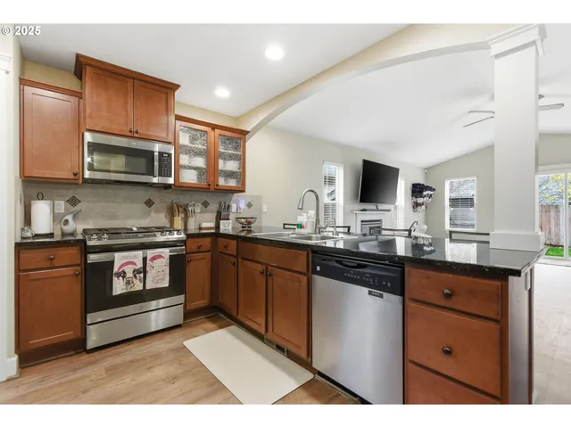 a kitchen with stainless steel appliances granite countertop a stove top oven a sink dishwasher and cabinets