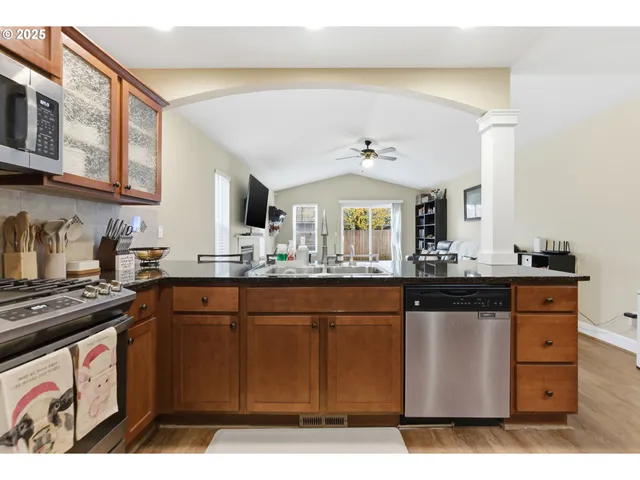 a kitchen with stainless steel appliances granite countertop a stove a sink and a microwave