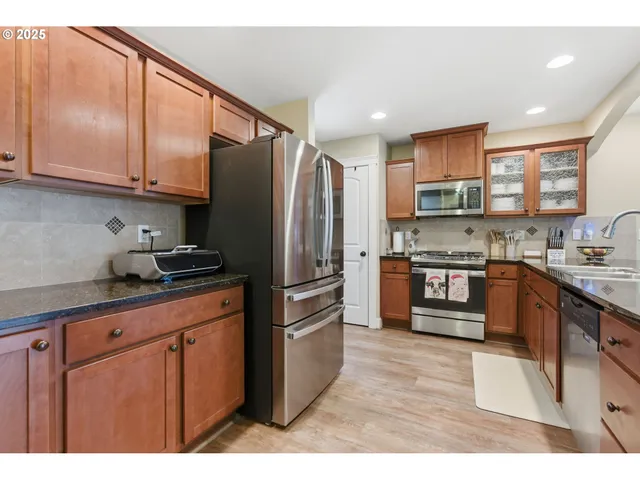 a kitchen with stainless steel appliances granite countertop a refrigerator sink and cabinets