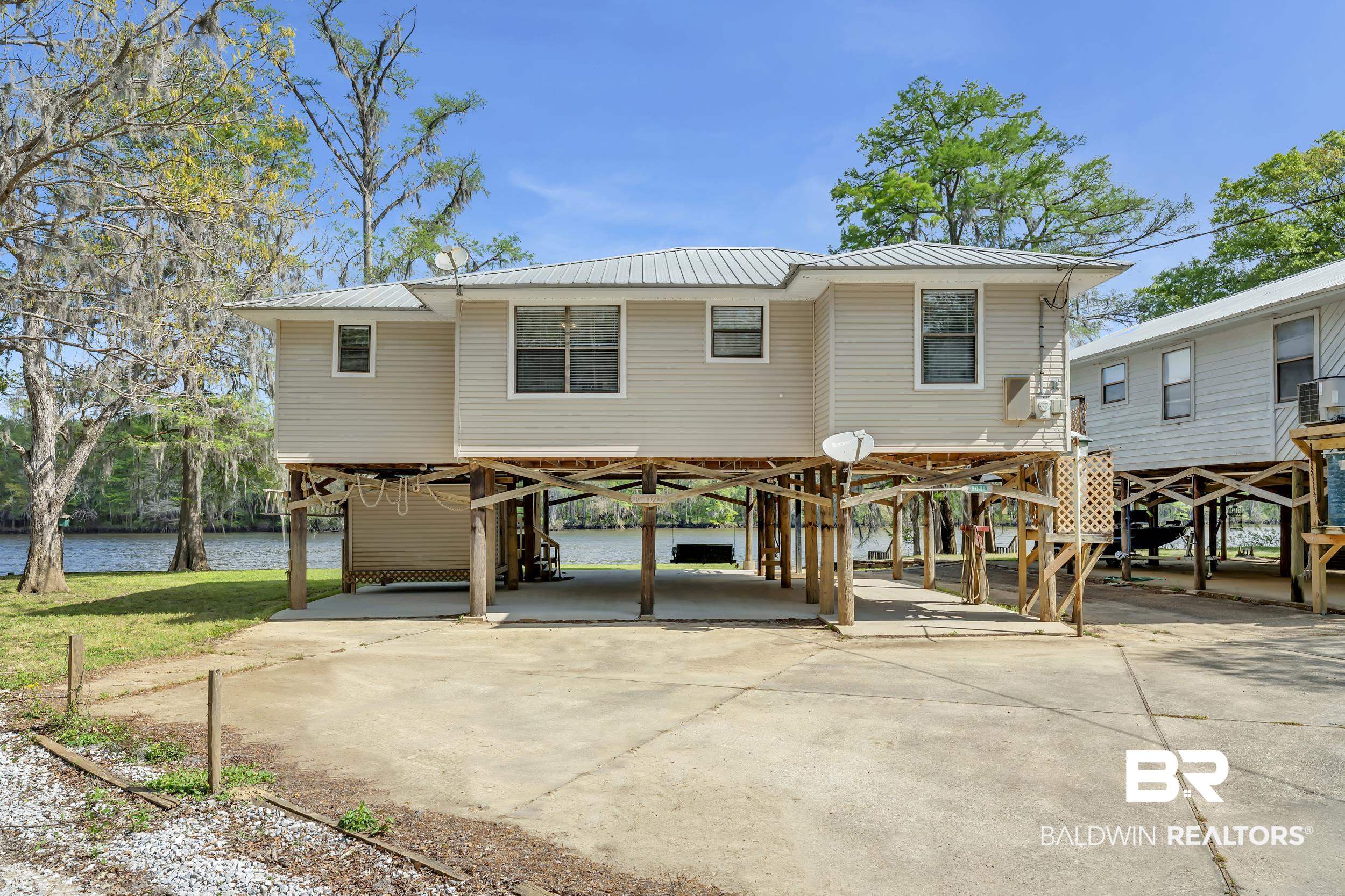 8081 Bryant's Lndg Road Stockton, AL 36579 - Photo 10 of 48 Rear view of house with a carport, a metal roof, driveway, and a water view