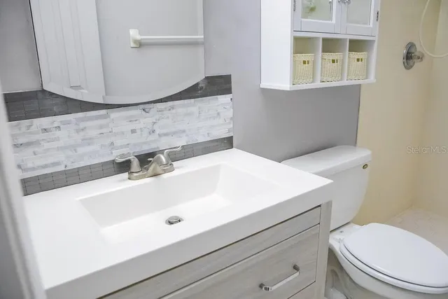 a bathroom with a sink a toilet and mirror