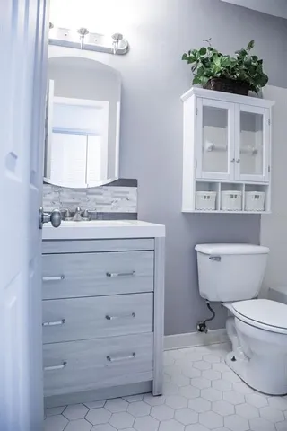 a bathroom with a toilet a sink and a mirror