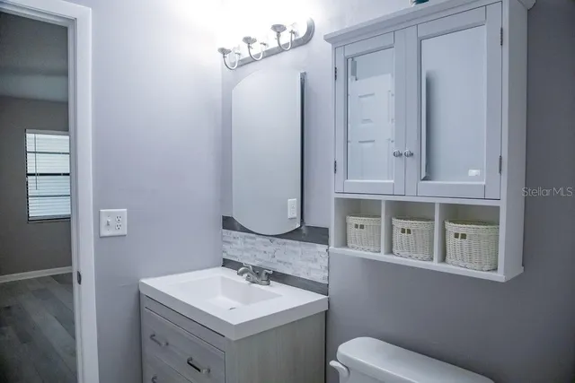 a bathroom with a toilet sink and mirror