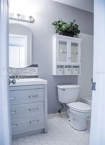 a bathroom with a toilet sink and mirror