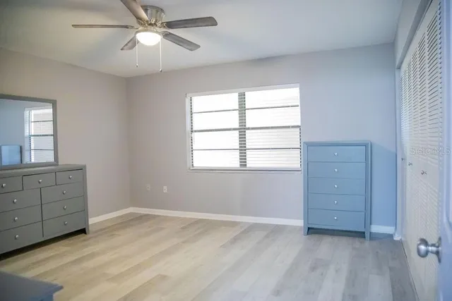 wooden floor in an empty room with a window and a dresser