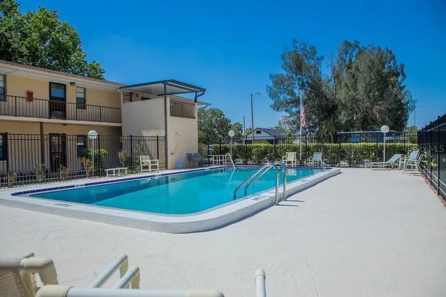 a view of a house with pool and chairs