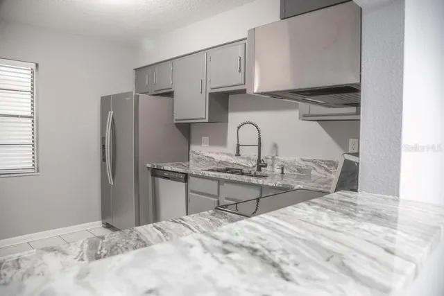 a kitchen with stainless steel appliances kitchen island a refrigerator sink and cabinets